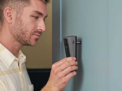 a photo of a man installing Ring Peephole Cam 2K