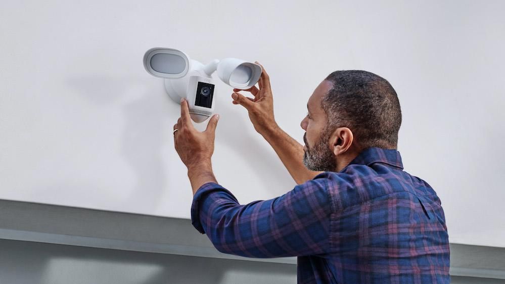 a person installing a Ring Floodlight Cam Wired Pro on a garage