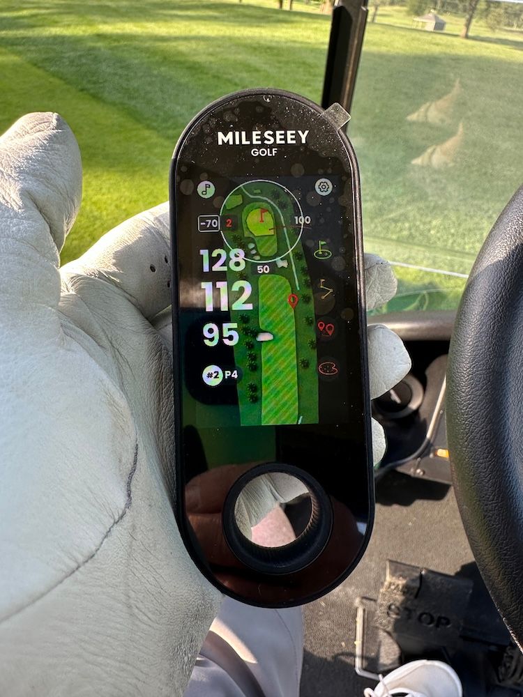 photo of Mileseey view finder in a golfer's hand on a golf course.