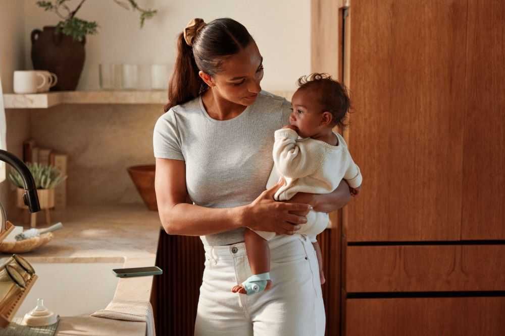 photo of a mother holding a baby with Owlet Sock