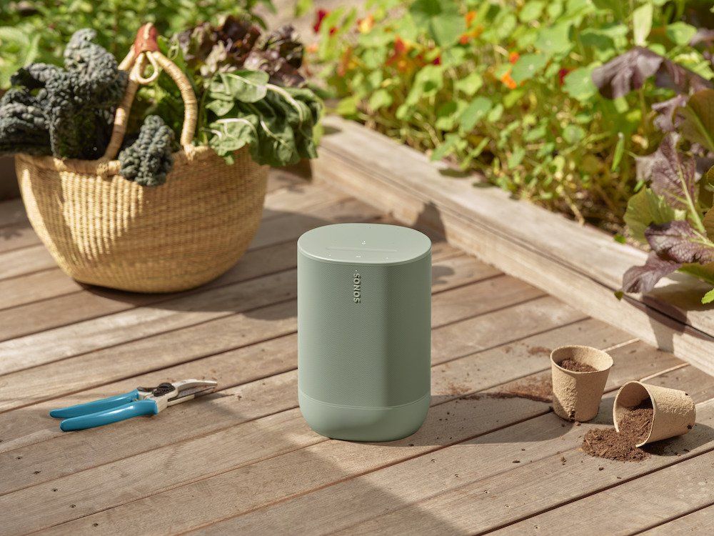 a photo of Sonos Move 2 speaker on a deck next to a garden