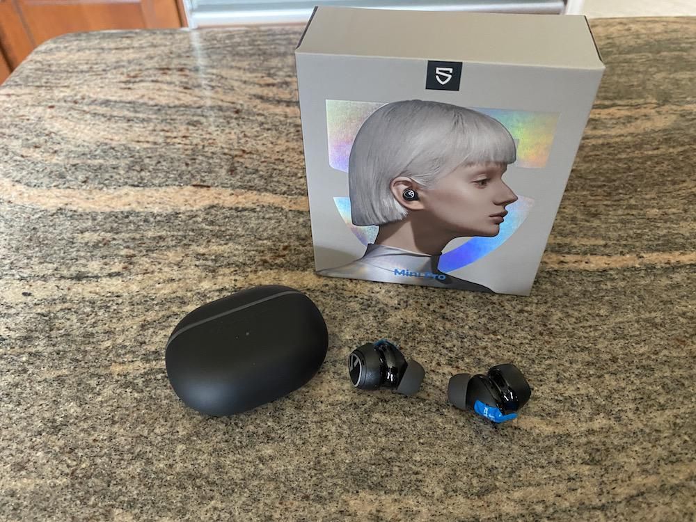 A photo of Soundpeats Mini Pro earbuds unboxed on a countertop