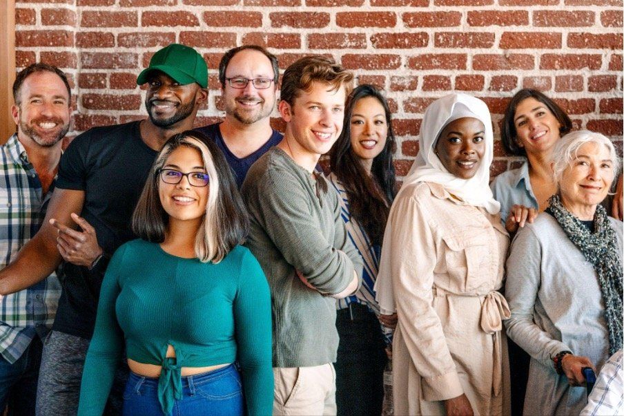 Group of diverse people standing in front of a brick wall