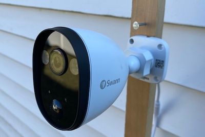 Swann Spotlight Outdoor Security Camera mounted outside a home.