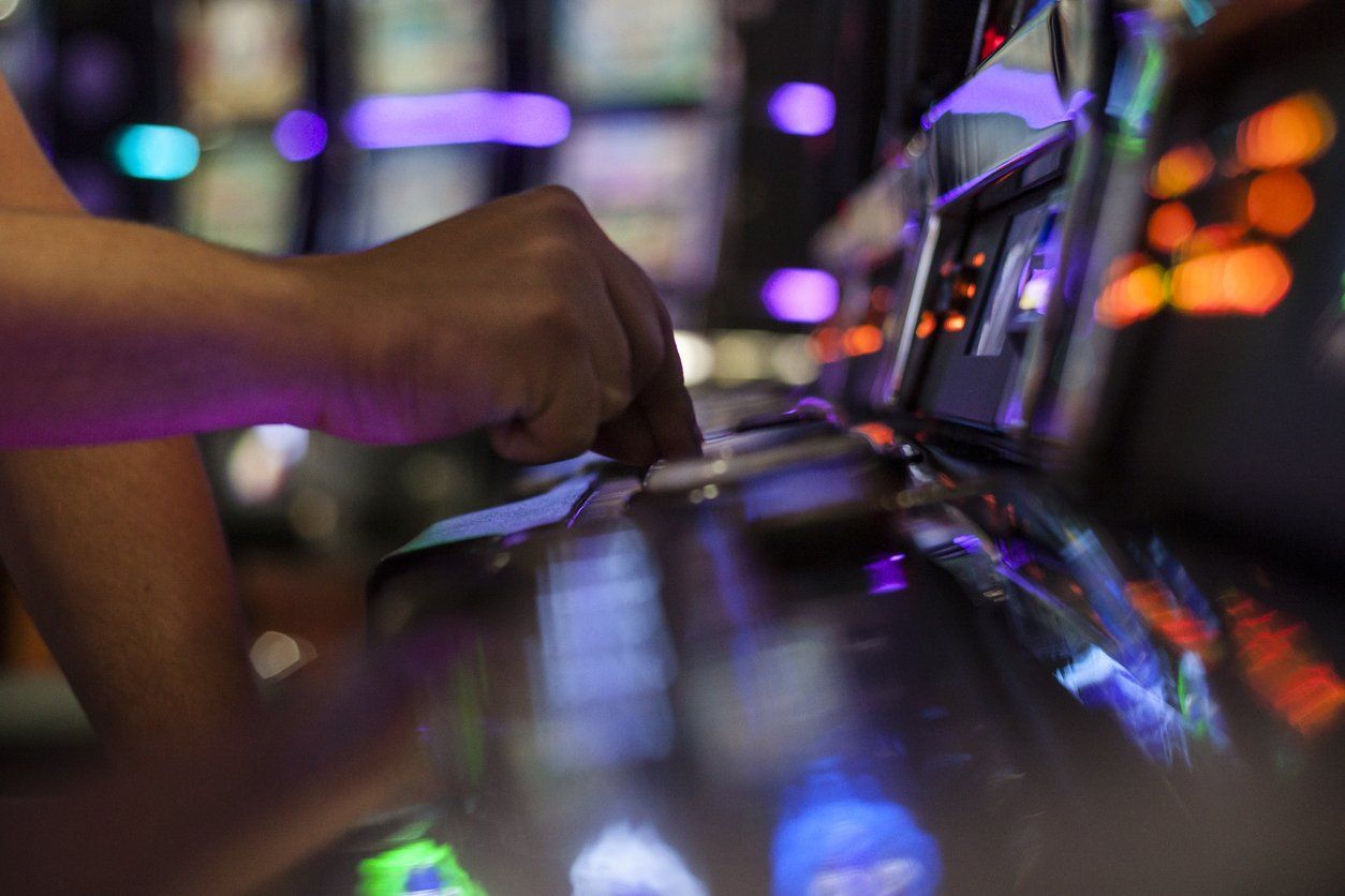 an adult man playing on a slot machine