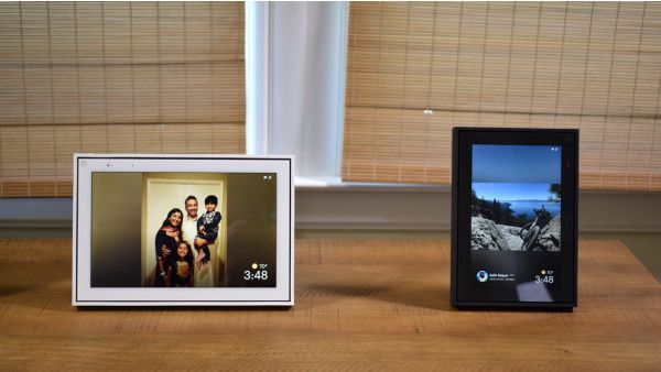 Two framed Portal devices, with screens, seated on a wooden table