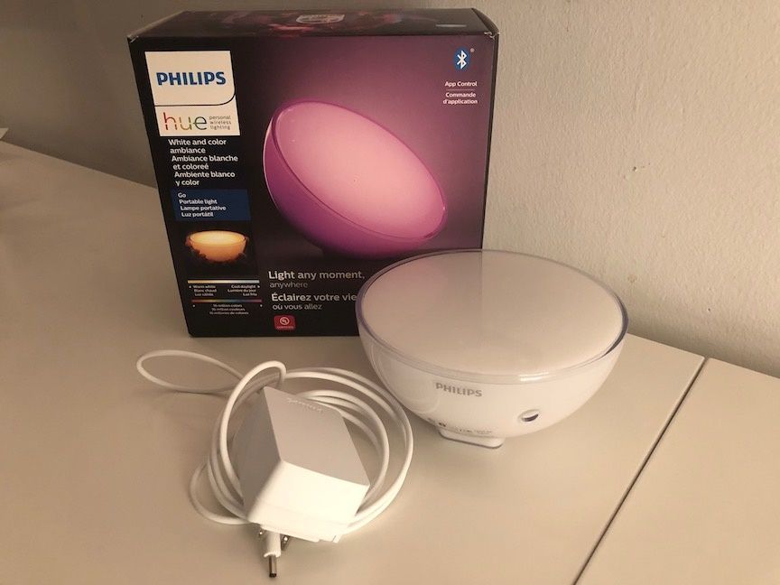 Philips Hue Go light with box and plug on a white table