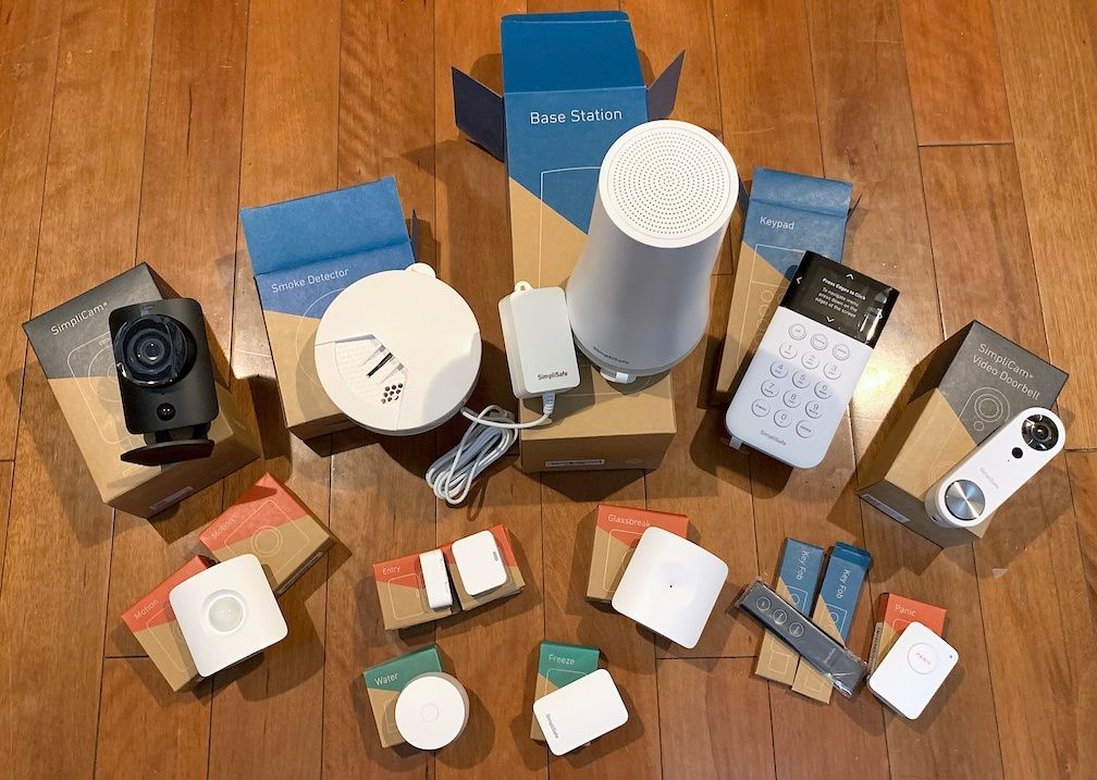 Devices on boxes on a wooden floor, including a key pad, sensors, a camera and wires