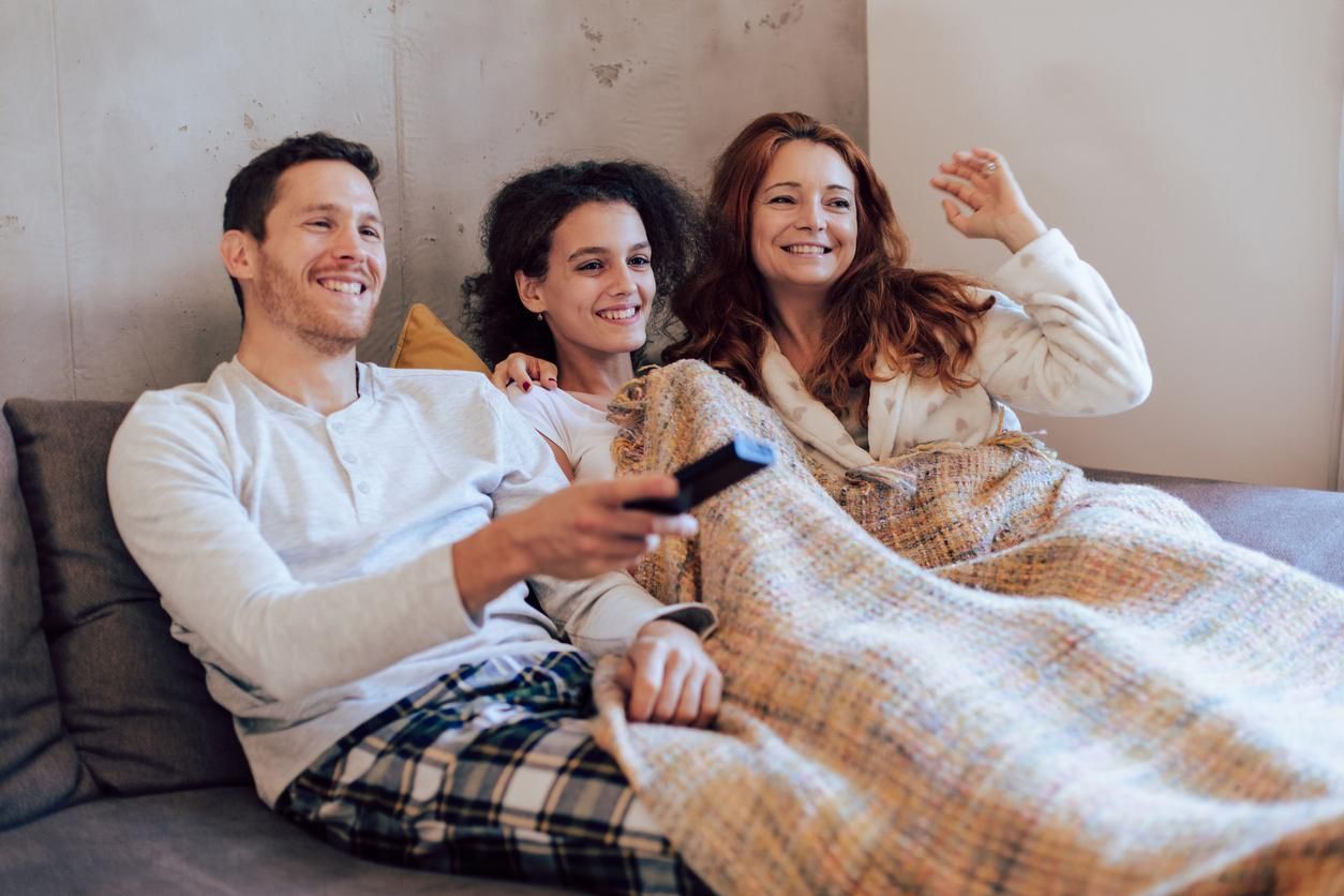 family on a couch watching  TV