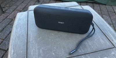 a photo of Tribit StormBox Flow Portable Wireless Speaker outside on a table.