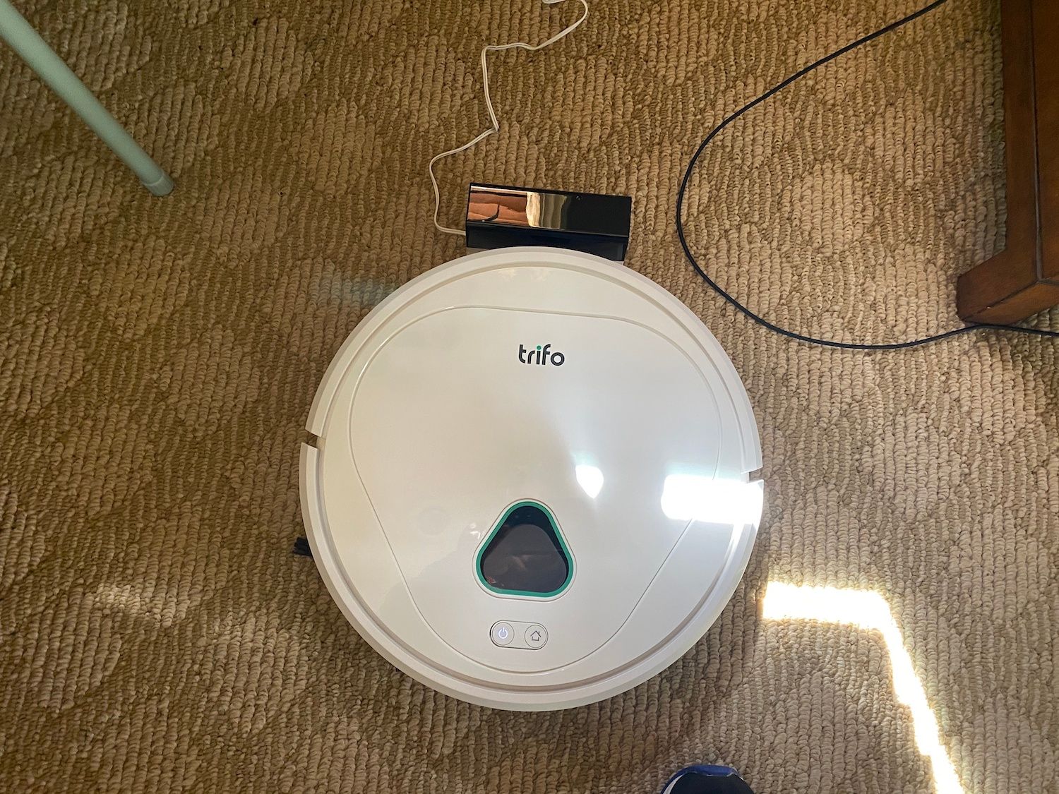 a photo of Trifo Max Home Surveillance Robot Vacuum on the floor charging.