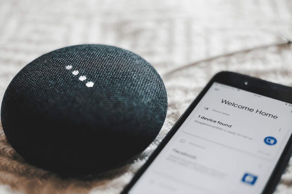a photo of google mini speaker and smartphone