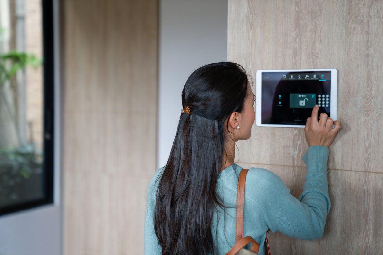 a woman entering a PIN to her smart home system