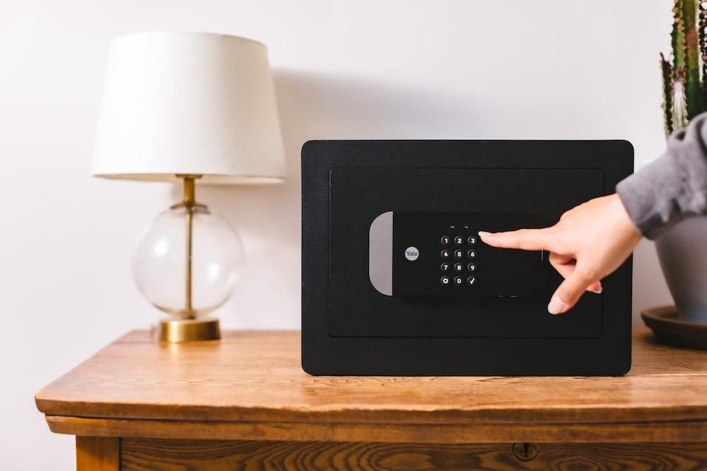 a photo of a woman unlocking Yale Smart Safe