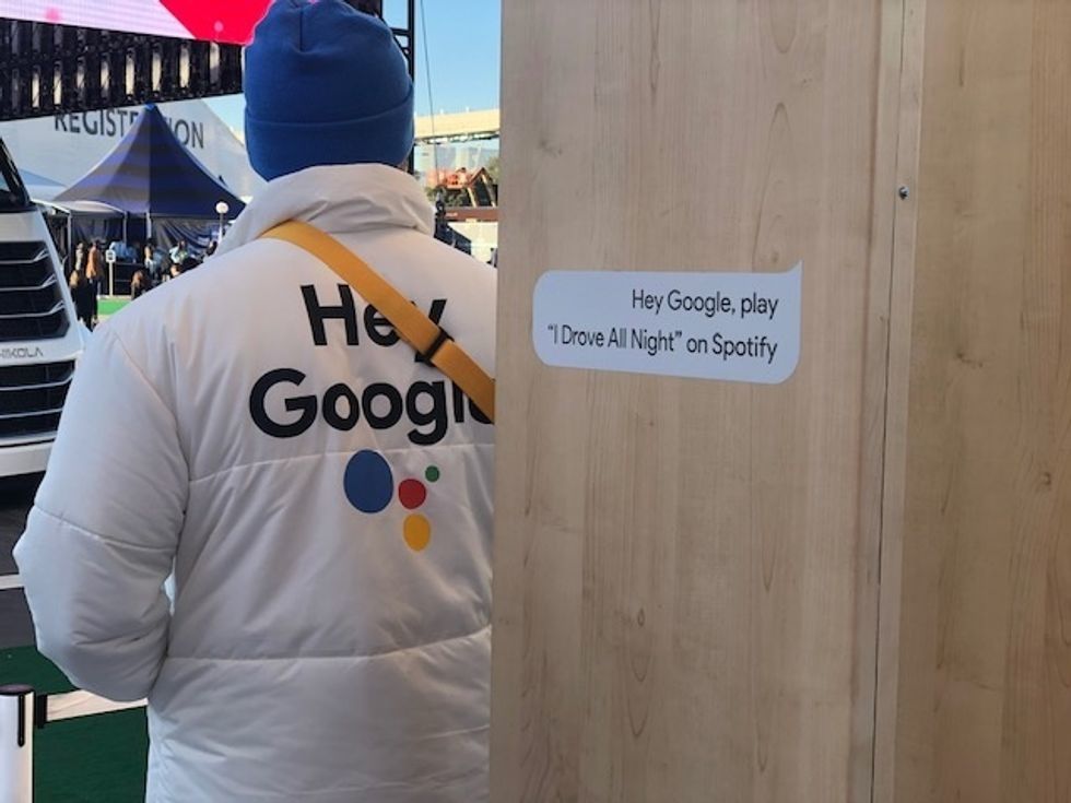 A man in a suit that advertises Google Assistant