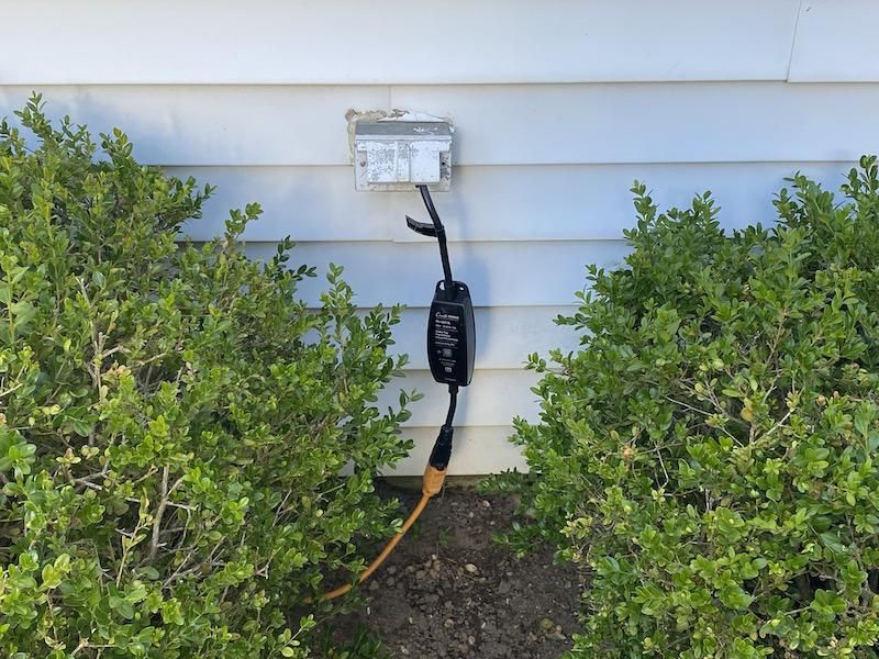 Lutron Outdoor Smart Plug plugged in an outlet outside a home.