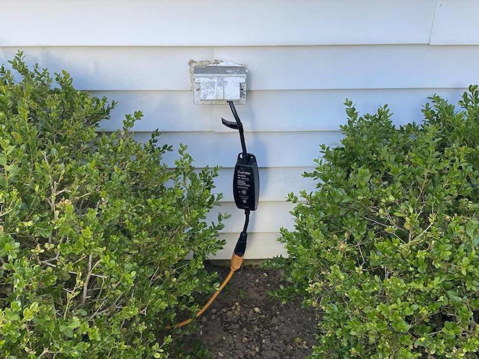 Lutron Outdoor Smart Plug plugged in an outlet outside a home.