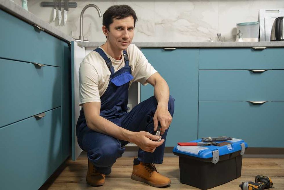 Male plumber working to fix problems at client's house