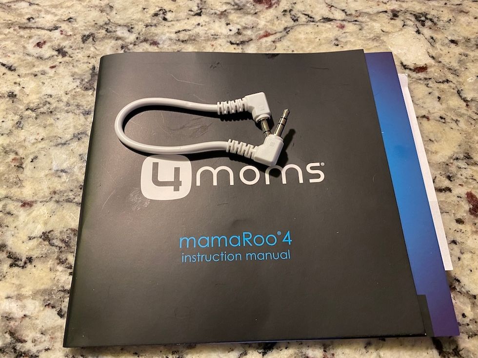 mamaRoo4 mp3 cord and instruction manual on a counter. Cord is short.