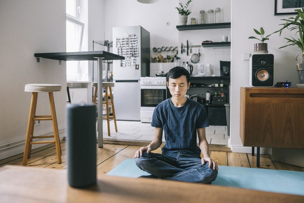 Man asking exercise advice from smart speaker stock photo