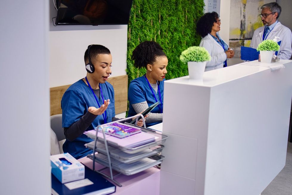 Nurse talking on telephone at hospital reception stock photo