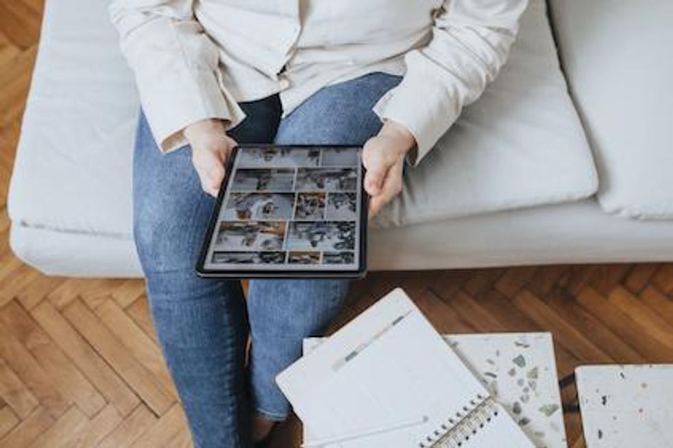 Person seated with a tablet looking at a photo library