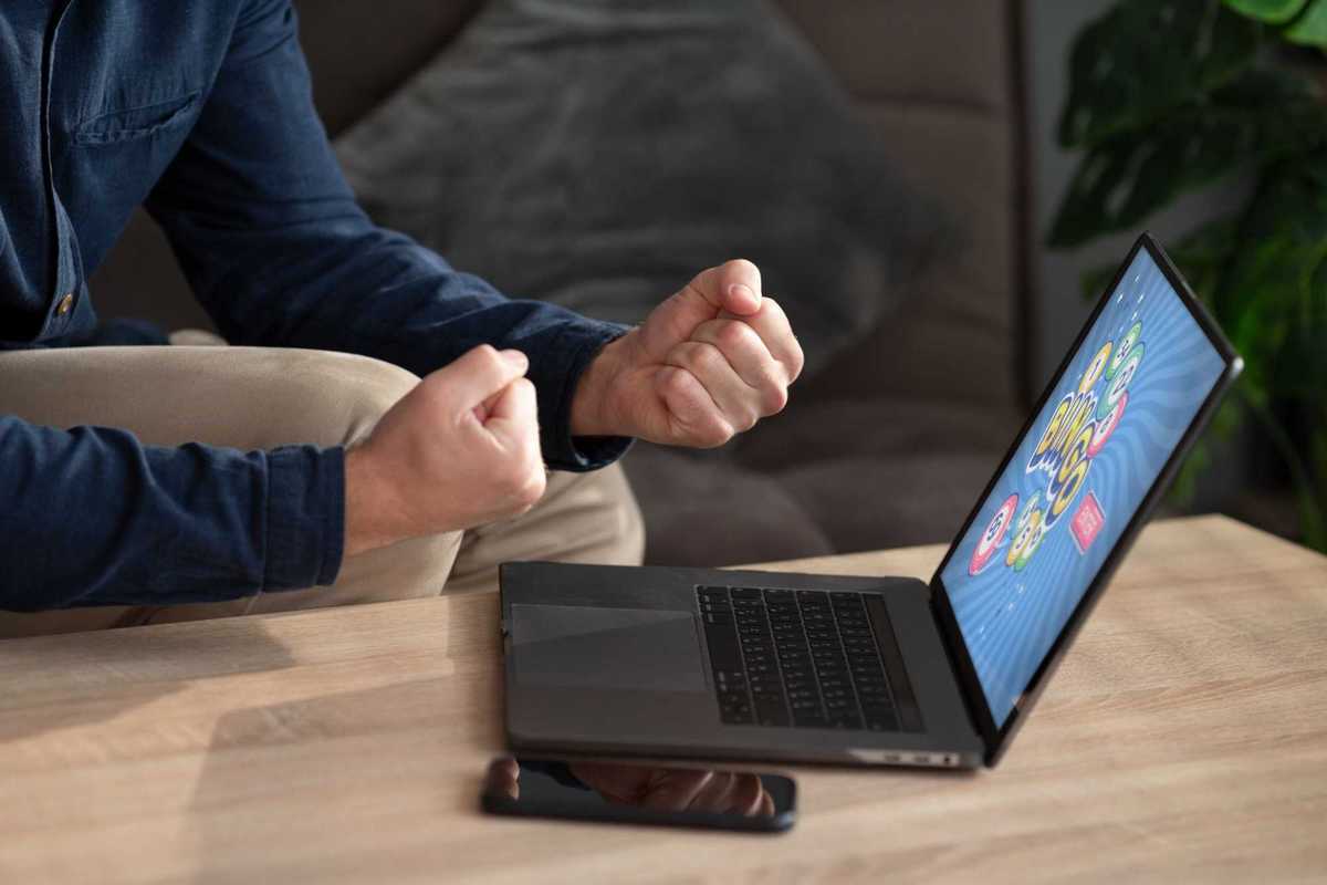 photo of a man playing a game on a laptop