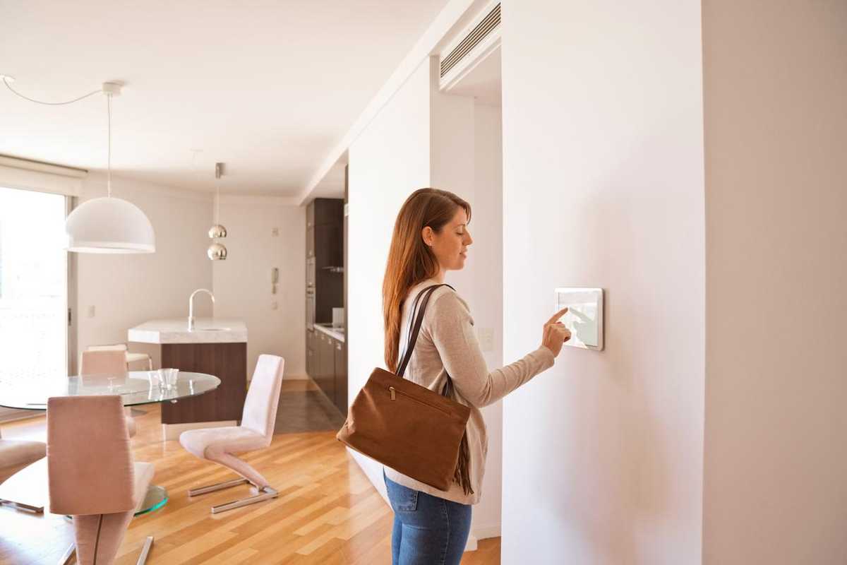 Photo of a woman activating a home security system