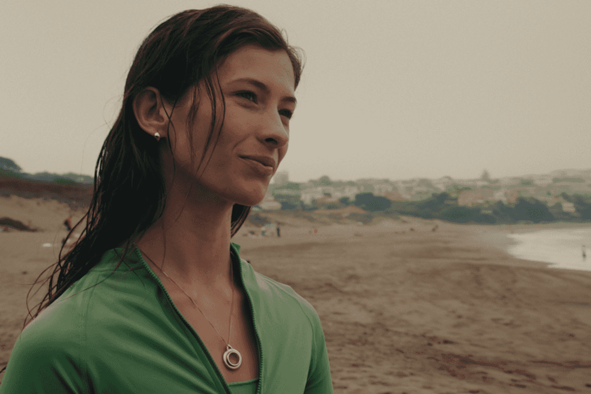 photo of a woman wearing Taya Necklace onh the beach on a cloudy day