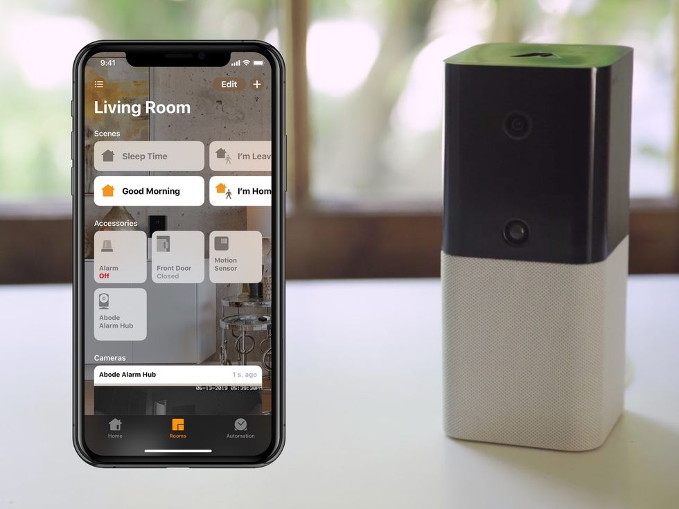 Photo of abode iota hub and smartphone with HomeKit app open and abode integration.