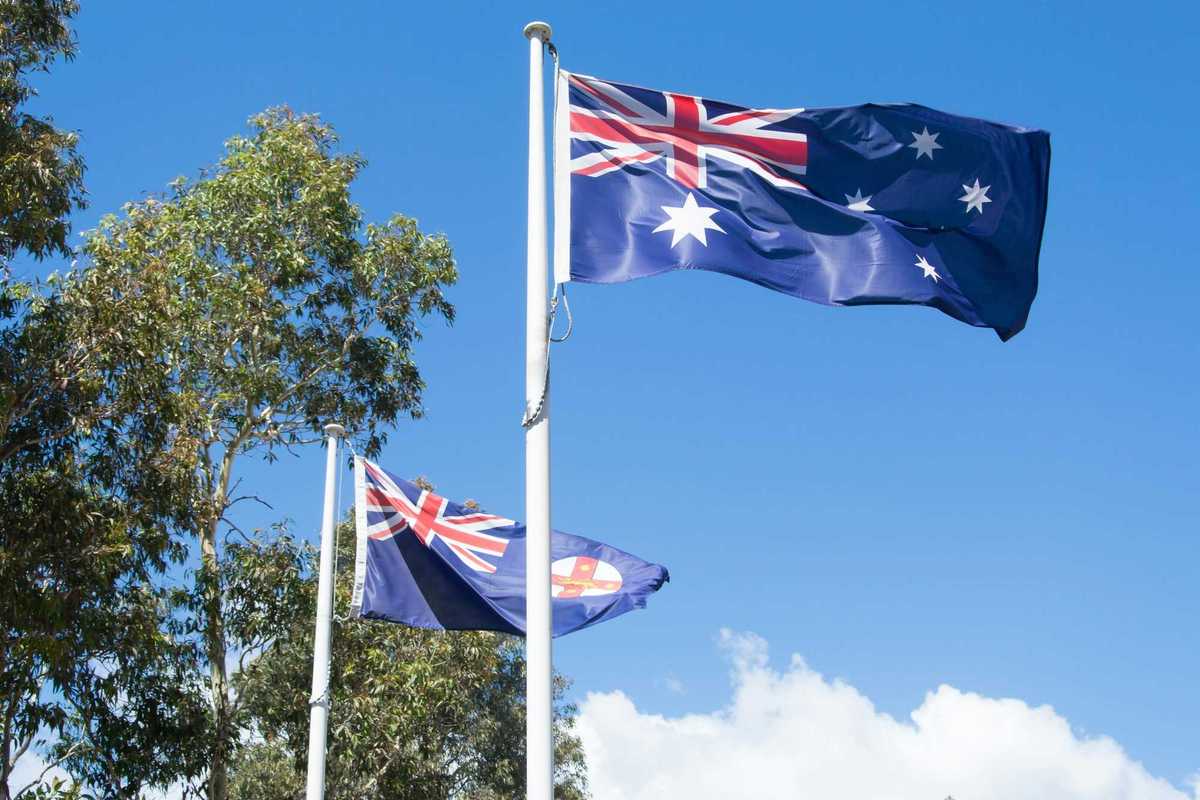 photo of Flying Australian flags with blue sky in Sydney, symbolizing patriotism and national pride