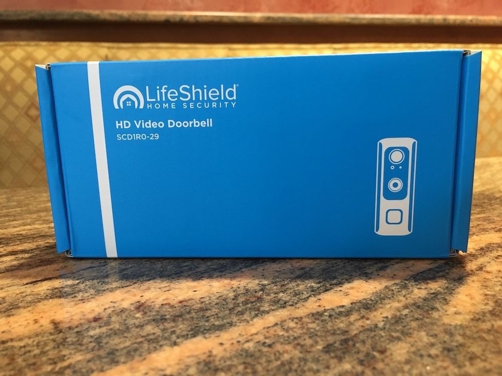 Photo of Lifeshield Home Security HD Video doorbell in the box on a counter.