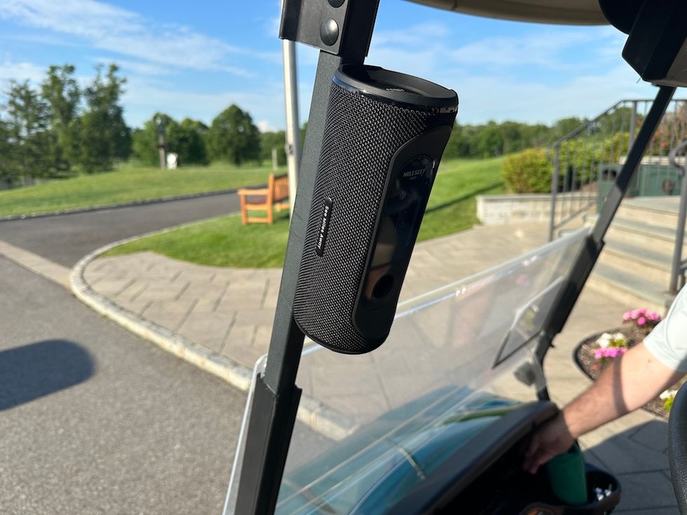 photo of Mileseey Genesonic Pro Golf GPS Speaker on a golf cart at a golf course.