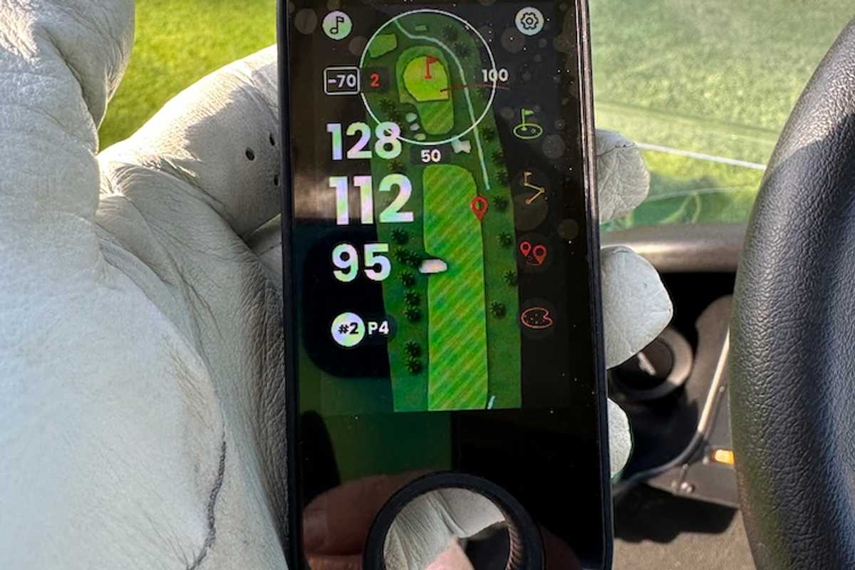 photo of Mileseey view finder in a golfer's hand on a golf course.