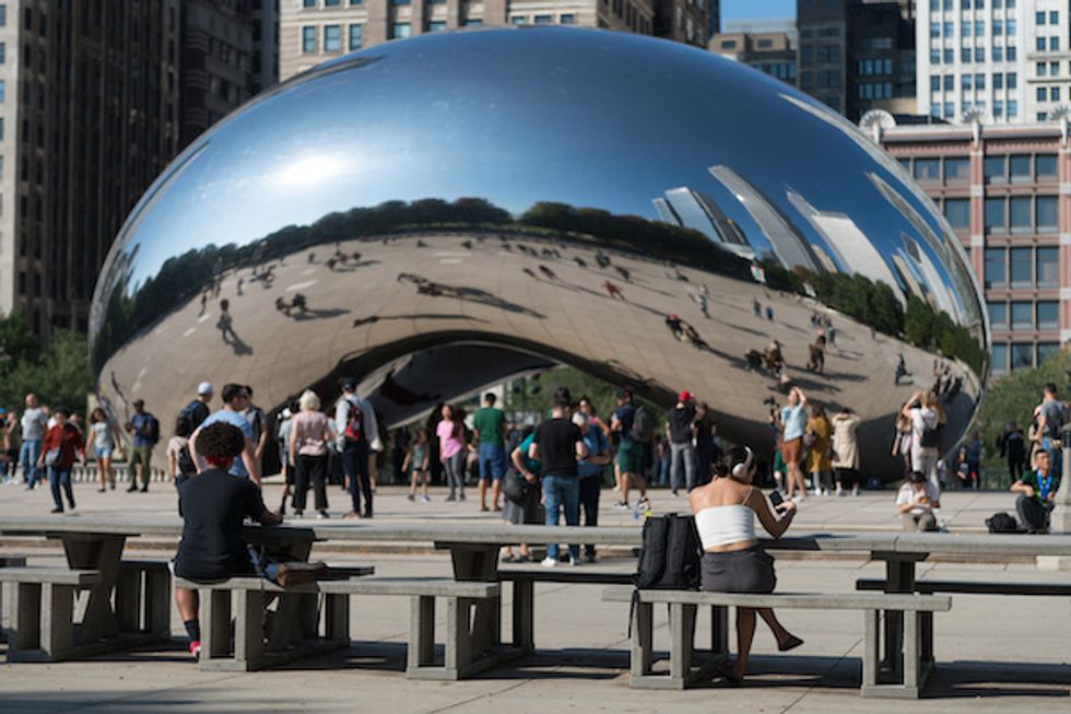 Photo of people sitting in Chicago's Millennium Park near Anish Karpoor's sculpture affectionately called "The Bean"