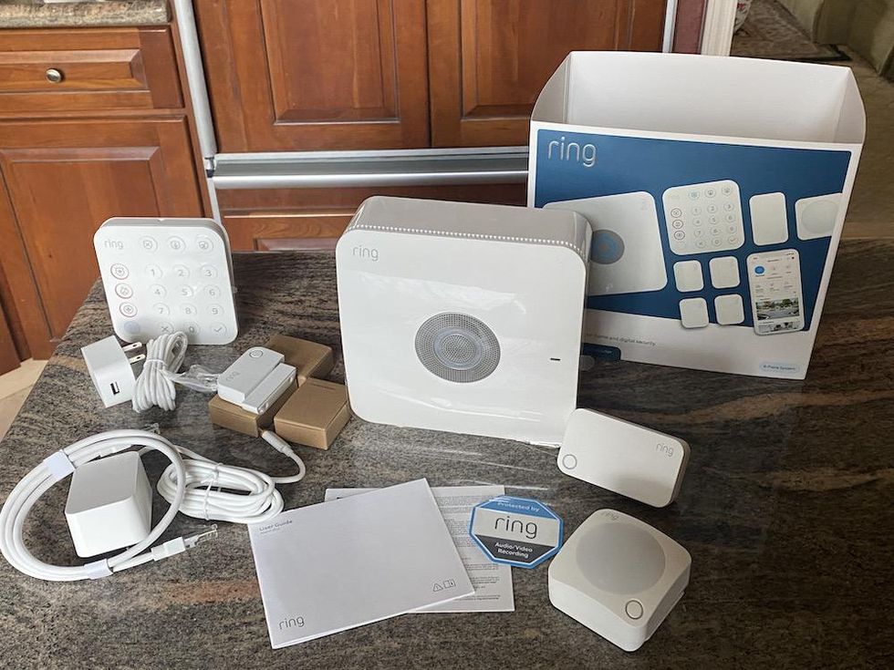 Photo of Ring Alarm Pro Security Kit, 8 pieces with eero Wi-Fi Router built-in on a countertop unboxed.