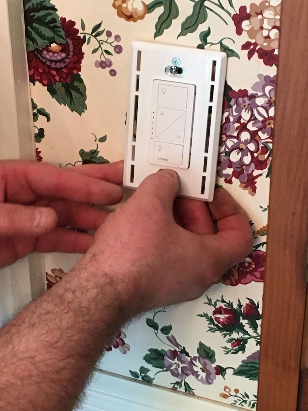 Photo of securing a mounting plate on a Lutron Caseta Switch