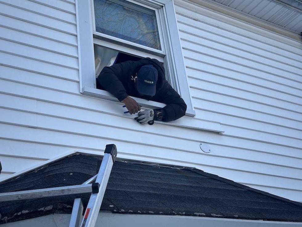 photo of Vivint installer setting up Vivint Outdoor Camera Pro gen 3 with spotlight.