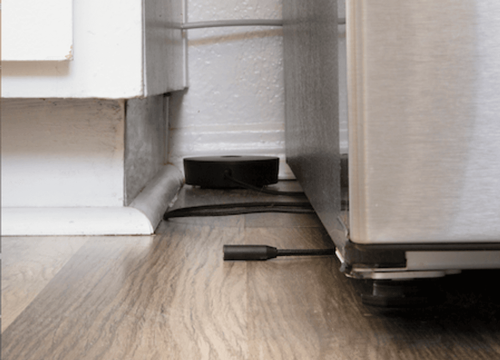 Phyn Water Sensor Cable underneath a refrigerator