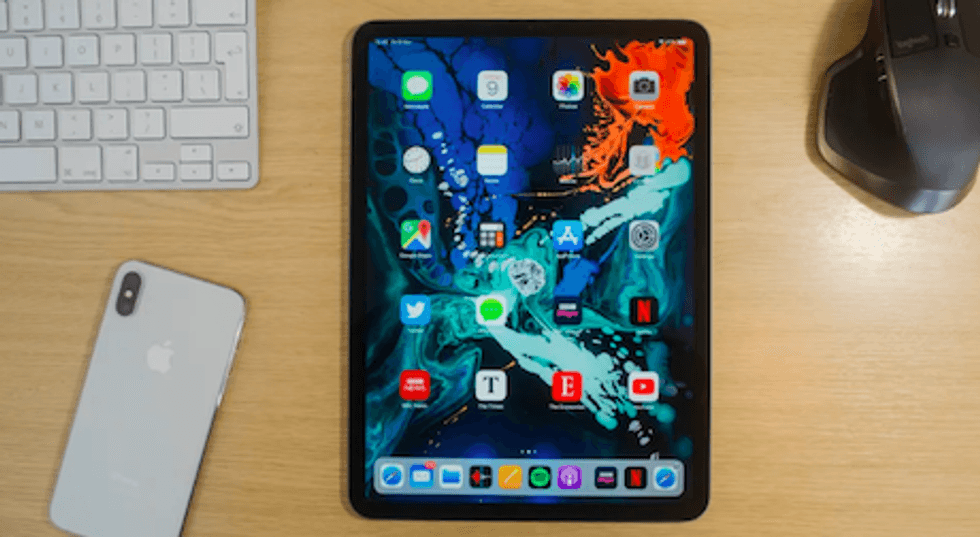 Picture of Apple iPad Pro 11 on a desk next to an iPhone.