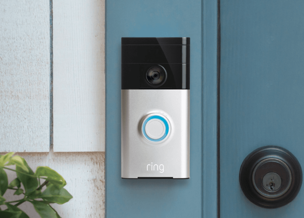 Picture of Ring video doorbell original next to a front door.