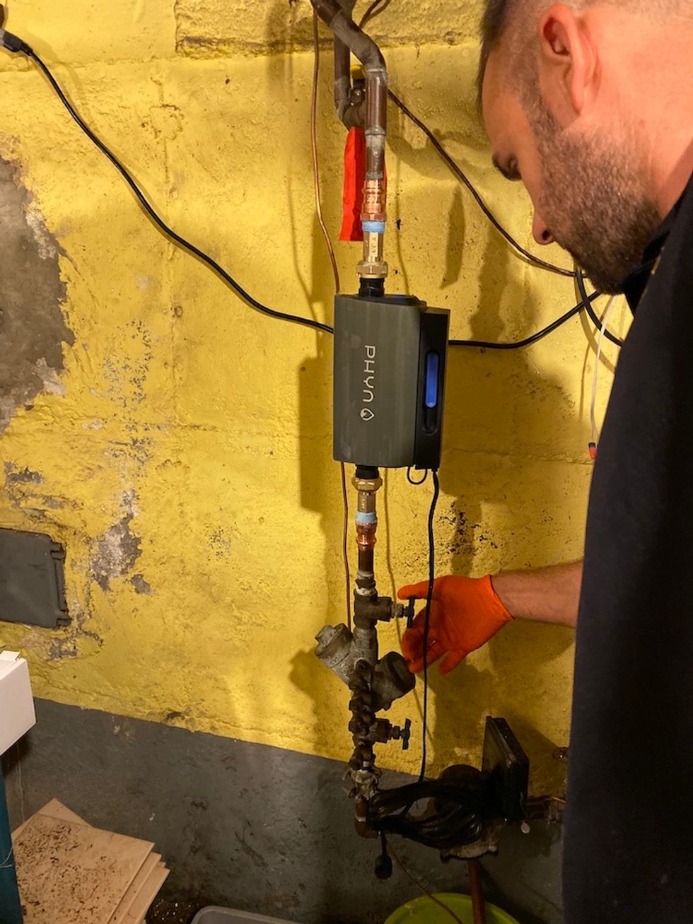 Plumber turning on water main after installing Phyn Plus