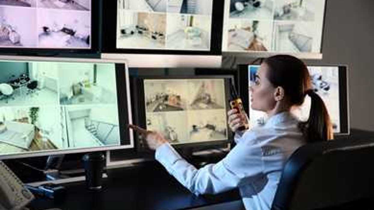 Security guard monitoring modern CCTV cameras in surveillance room