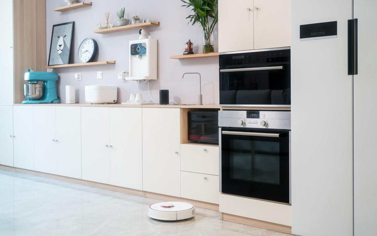 a photo of smart appliances in a kitchen with robot vacuum.