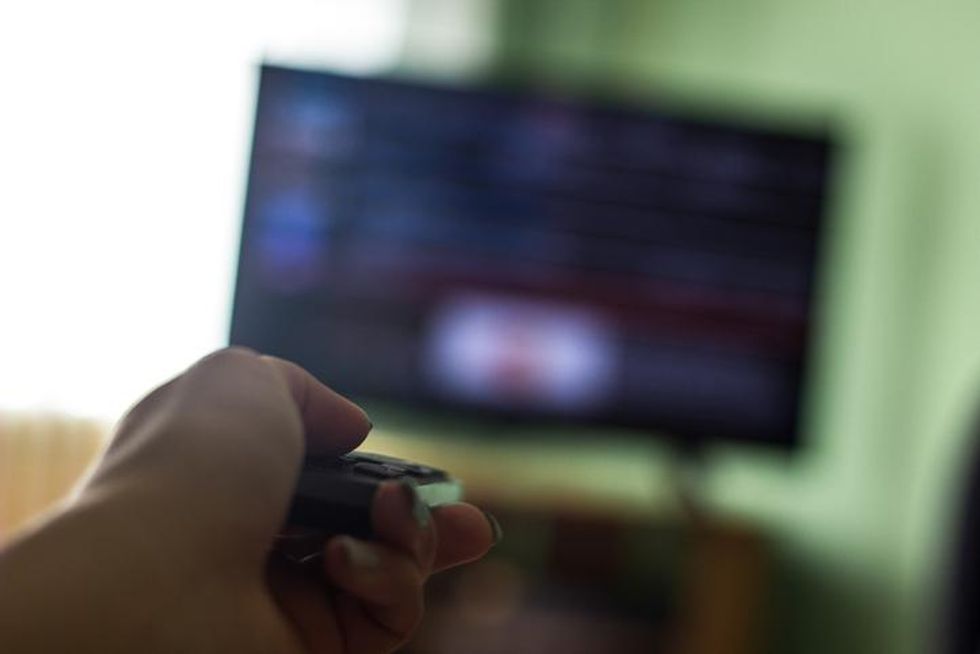 Someone holding a remote in front of a TV