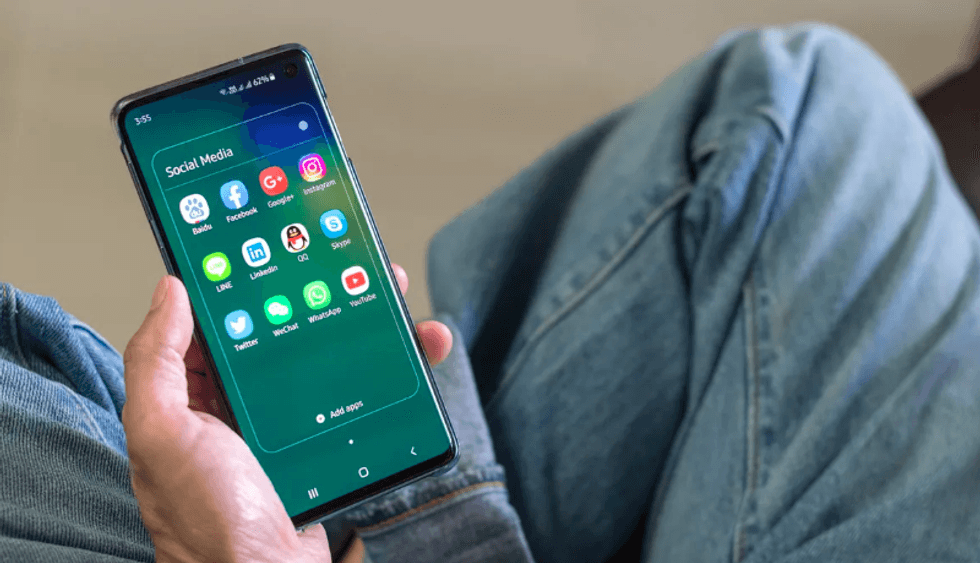 Someone holding a smartphone with social media apps open