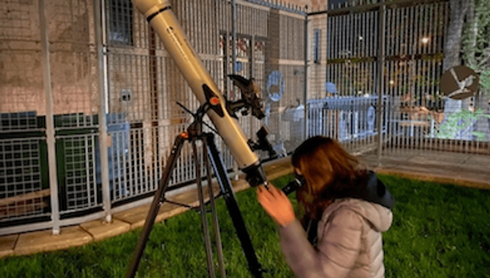 Someone looking through a telescope