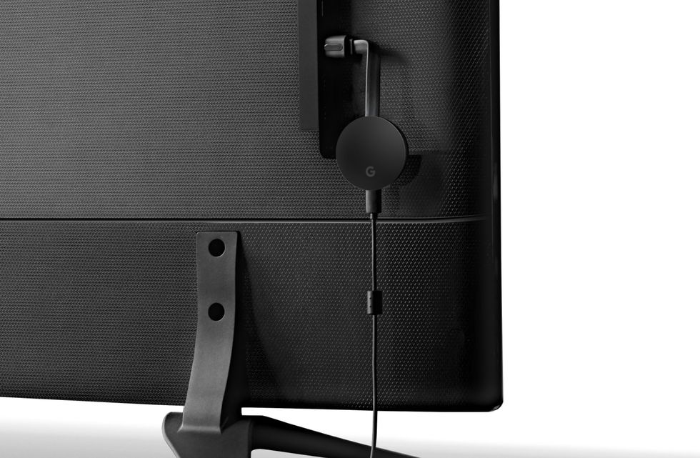 The Chromecast Ultra dongle attached to the back of a television