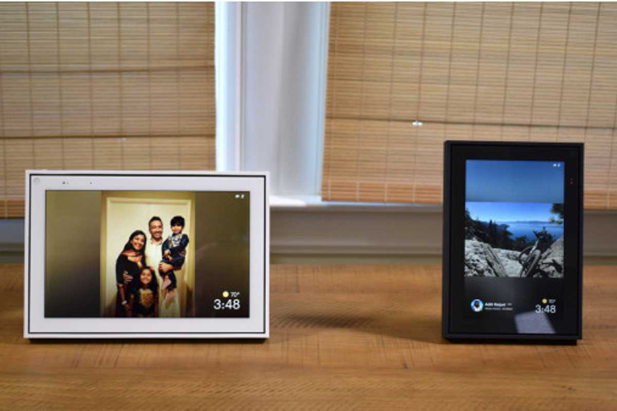 Two framed Portal devices, with screens, seated on a wooden table