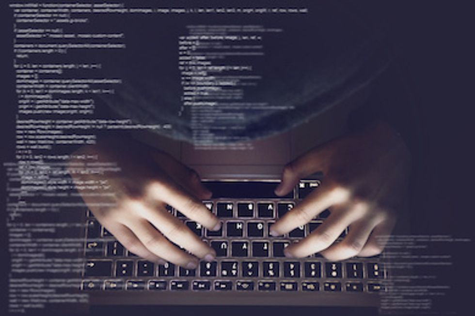 Two hands typing on a computer laptop